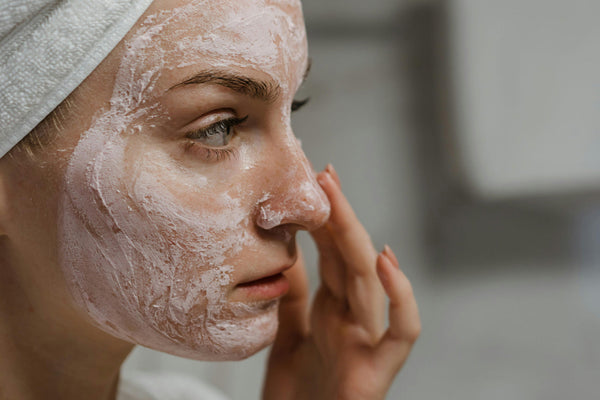 Woman applying exfoliating cream to face to brighten dull skin